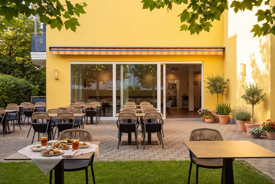 Gelbe Fassade des Hauses an der Rothusstrasse mit der Terrasse davor (Symbolbild auf Basis einer Aufnahme des Lokals)